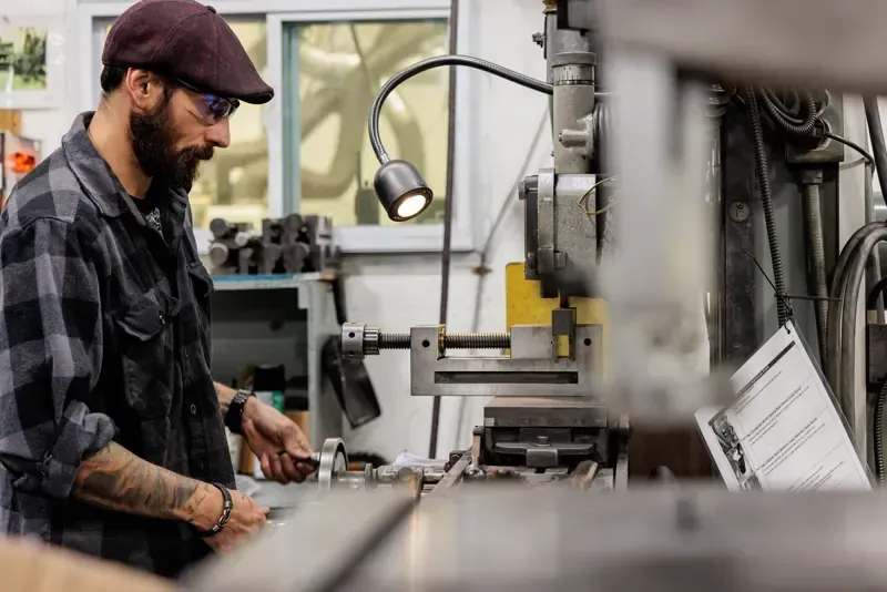 An FMI employee working in a production room and operating a machine.